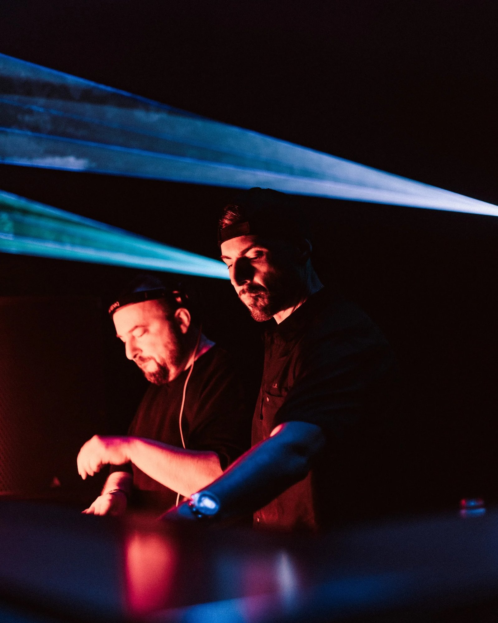 Still Young behind the decks, backlit by blue beams